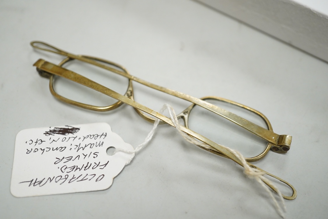 Three pairs of early 19th century base metal slider spectacles, pseudo hallmarks, one also stamped Pebbles, and two pairs of similar temple spectacles, the pair with turn pin sides also stamped pebbles, the pair with obl